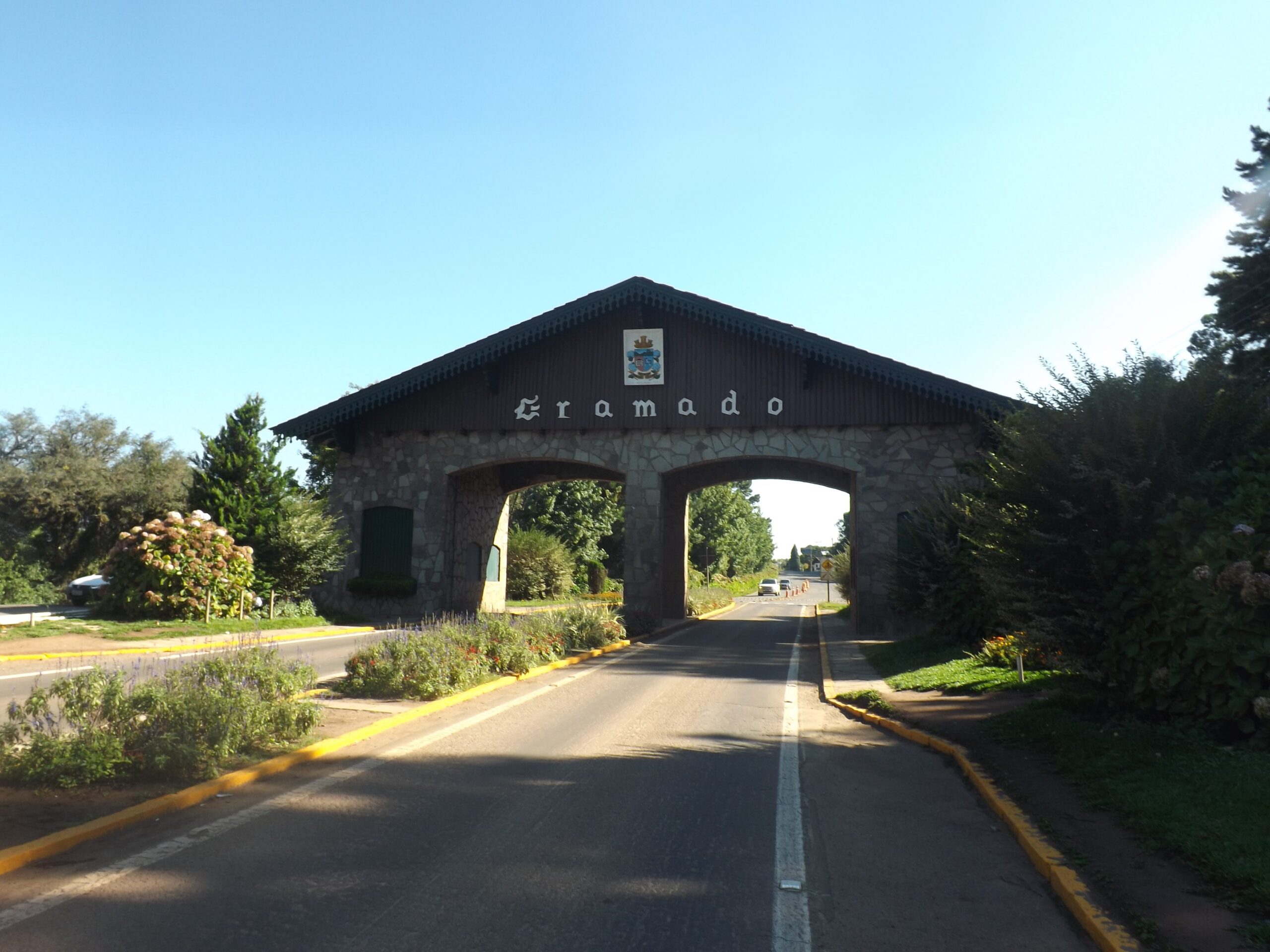 Pórtico de entrada de Gramado em dia de céu azul.